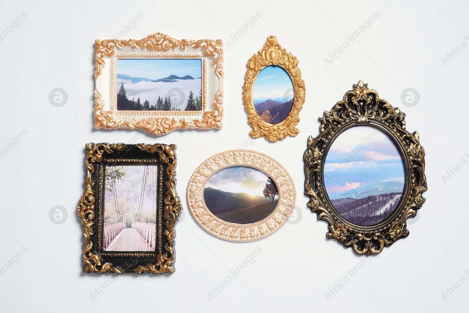 Photo of Vintage frames with photos of beautiful landscapes hanging on white wall