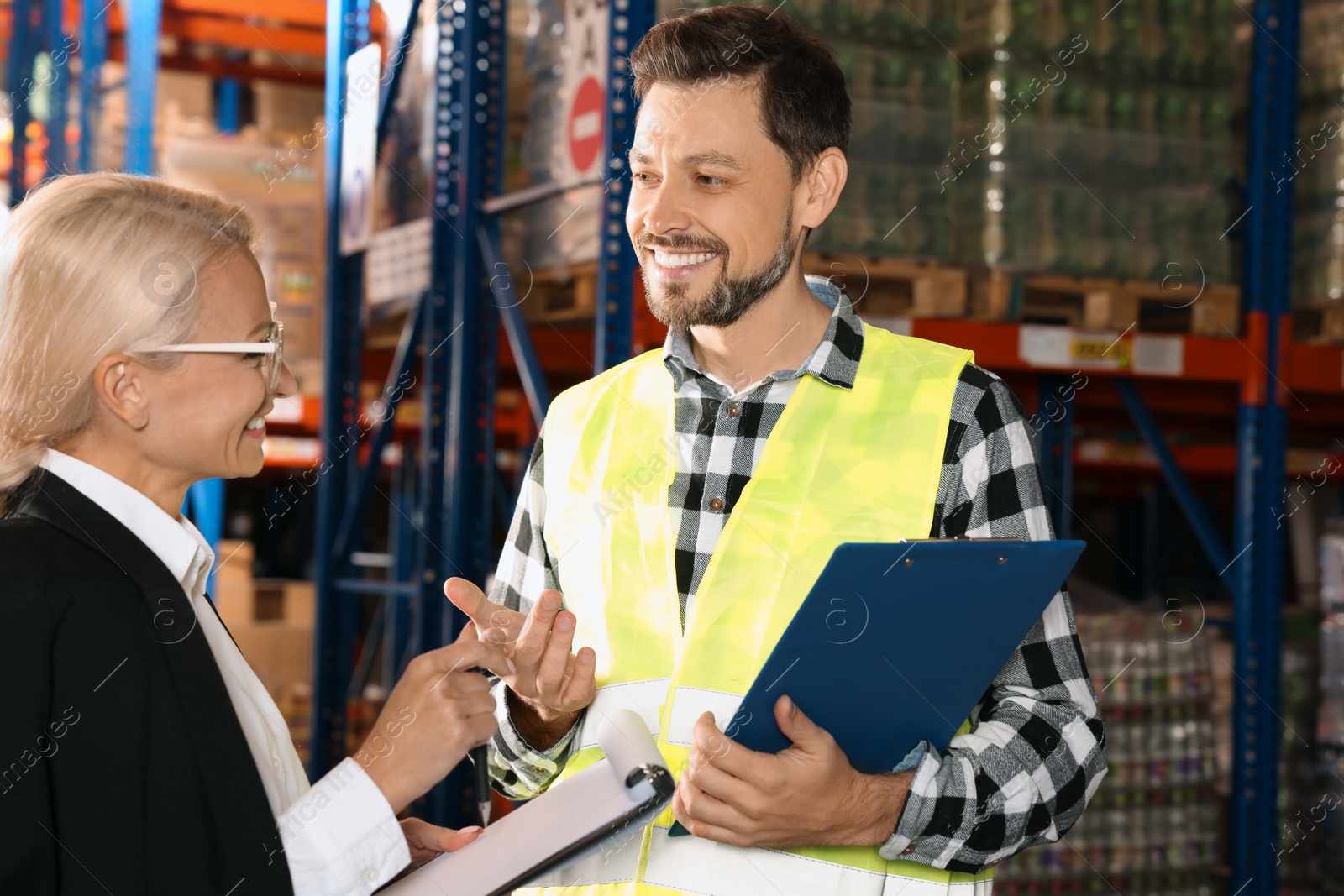 Photo of Manager and worker in warehouse with lots of products