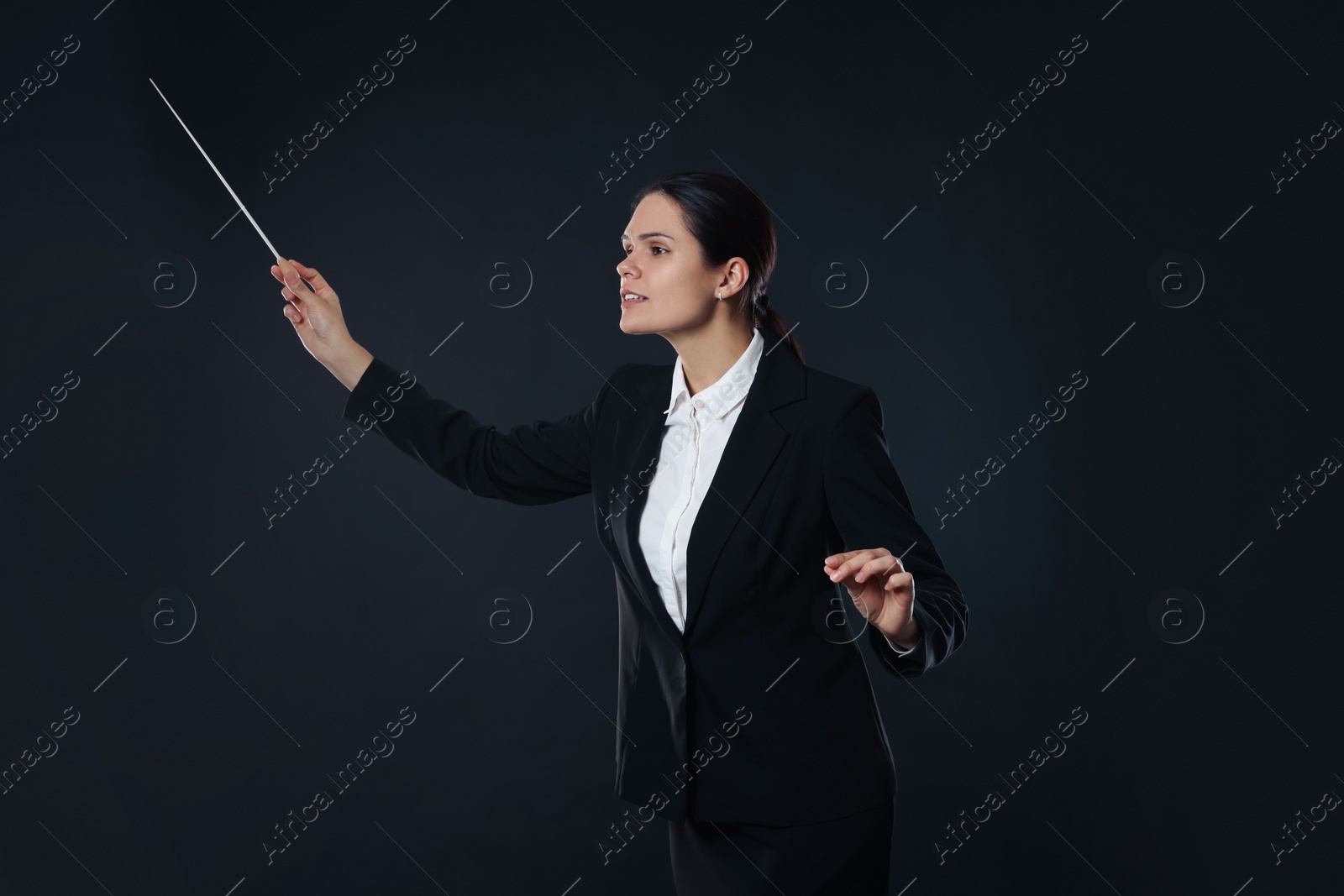 Photo of Professional conductor with baton on dark background