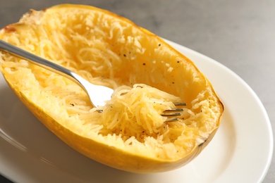 Photo of Plate with spaghetti squash and fork on table