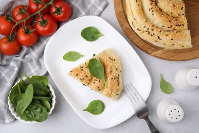 Photo of Piece of delicious puff pastry with spinach on light table, flat lay