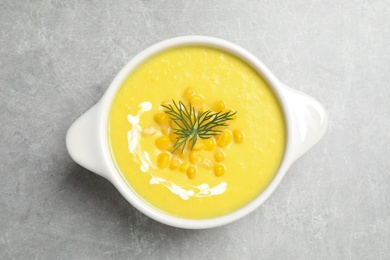 Delicious creamy corn soup on grey table, top view