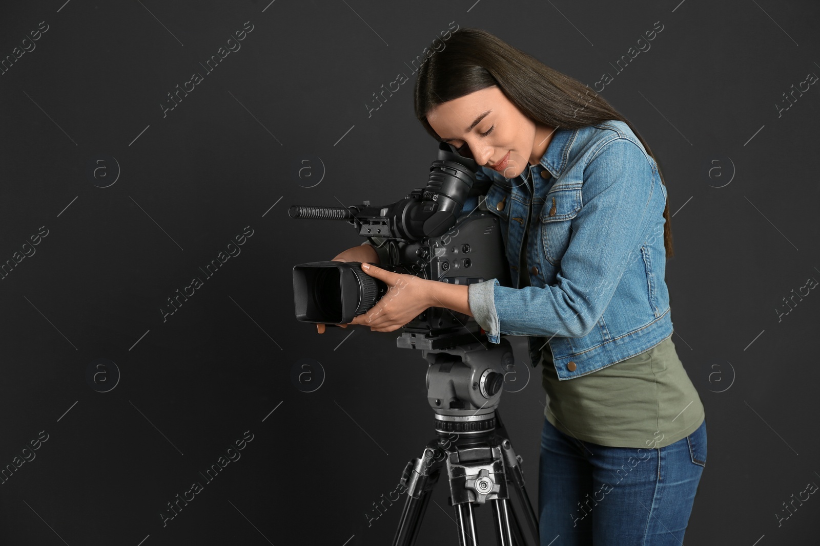 Photo of Operator with professional video camera on black background