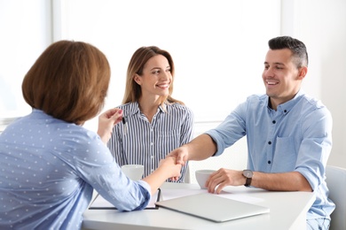 Real estate agent consulting young couple in office