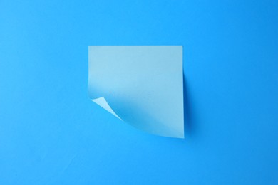 Photo of Blank paper note on light blue background, top view