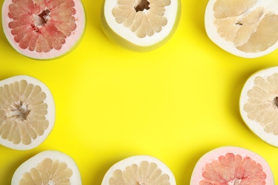 Photo of Fresh cut pomelo fruits on yellow background, flat lay. Space for text