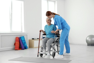 Photo of Professional physiotherapist working with elderly patient in rehabilitation center