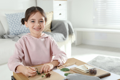 Photo of Little girl working with natural materials at table indoors, space for text. Creative hobby