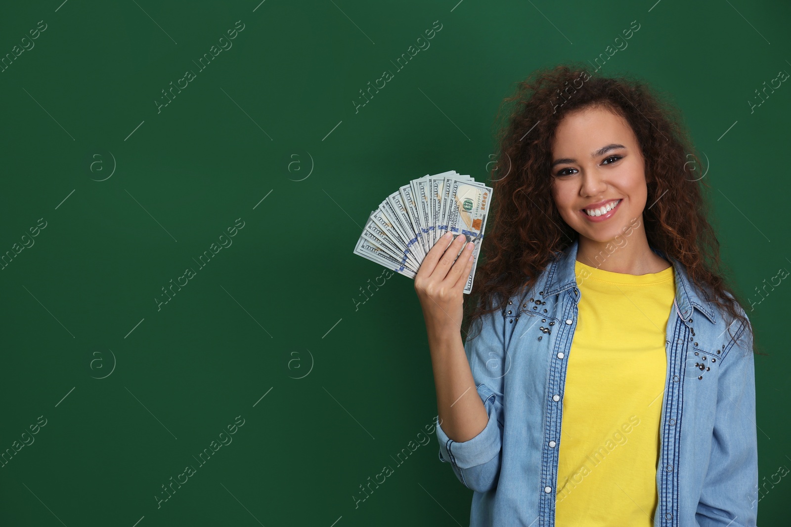 Photo of Young African-American woman with money on color background. Space for text