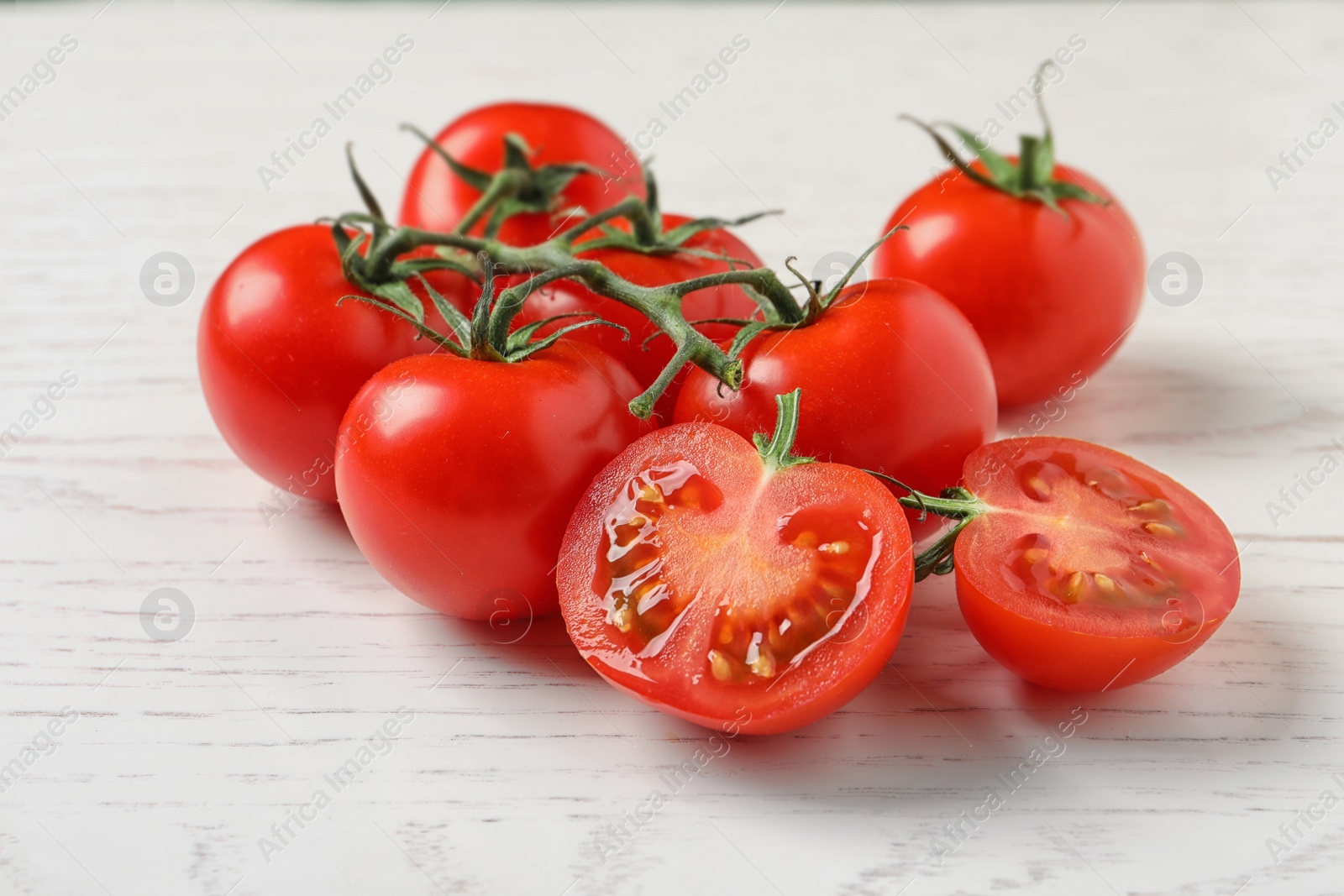 Photo of Fresh cherry tomatoes on white wooden background, closeup