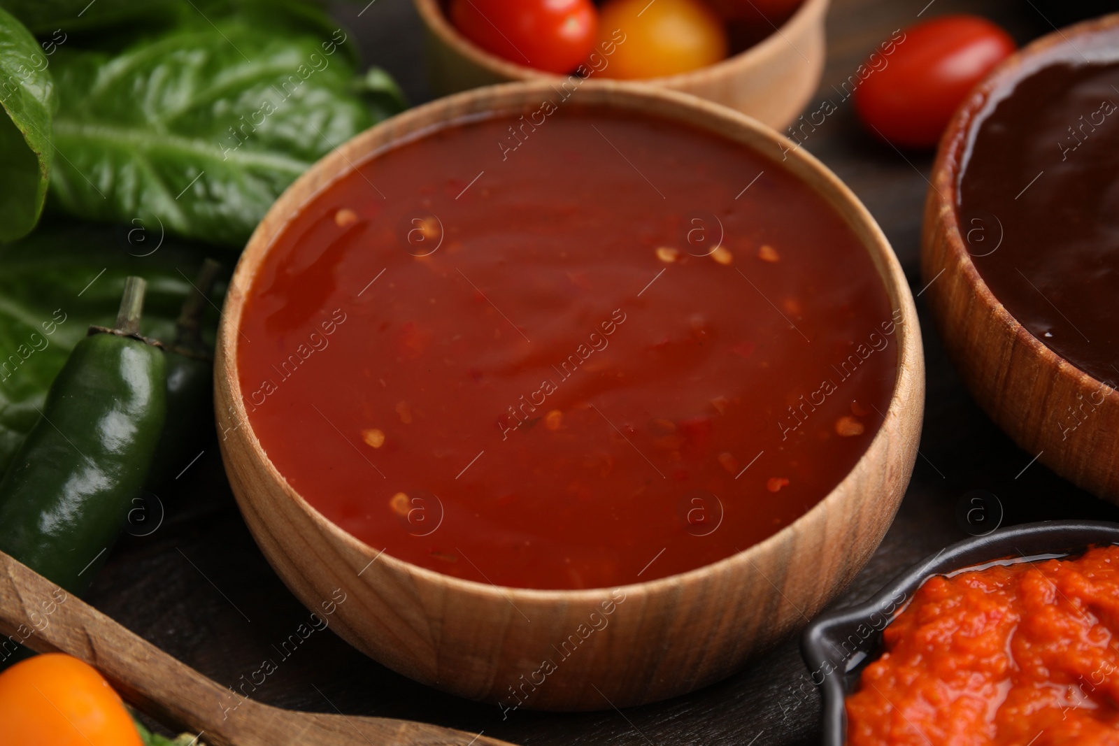 Photo of Homemade marinade in bowl on wooden table, closeup