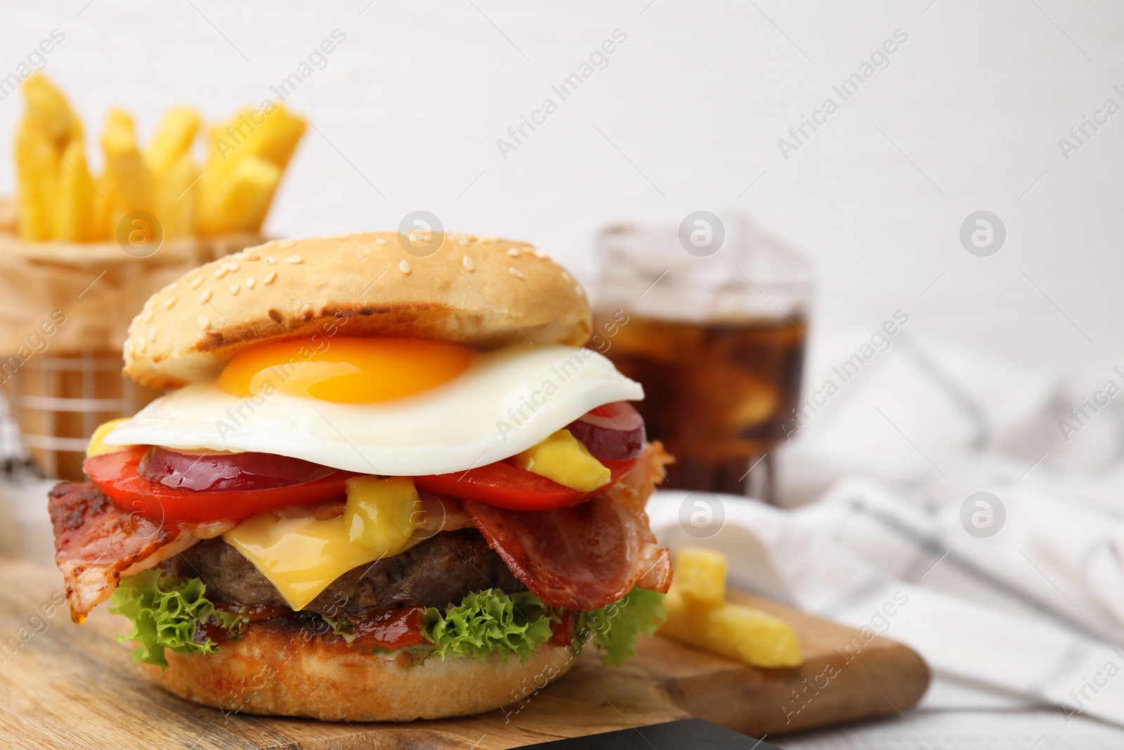 Photo of Delicious burger with fried egg on table, closeup. Space for text