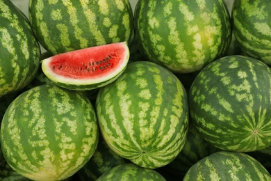 Photo of Delicious ripe whole and cut watermelons, closeup
