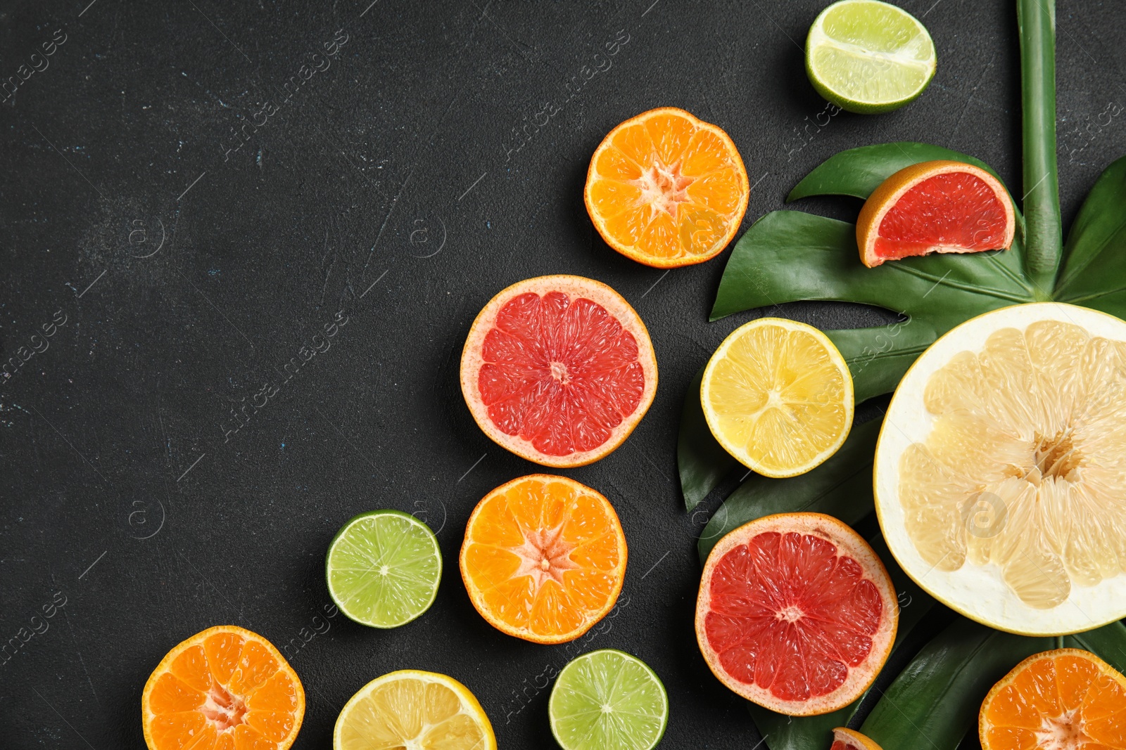 Photo of Different citrus fruits on black background, flat lay. Space for text