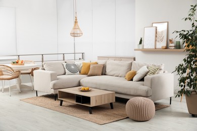 Stylish living room interior with comfortable grey sofa and coffee table