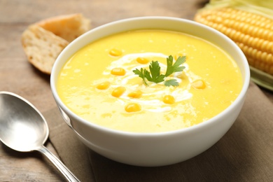 Photo of Delicious creamy corn soup served on table, closeup