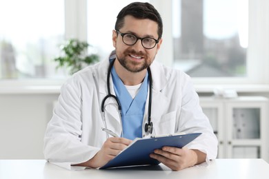 Photo of Portrait of smiling doctor at table in clinic