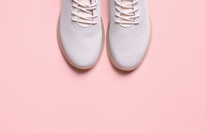 Photo of Stylish sporty sneakers on pink background, top view. Space for text