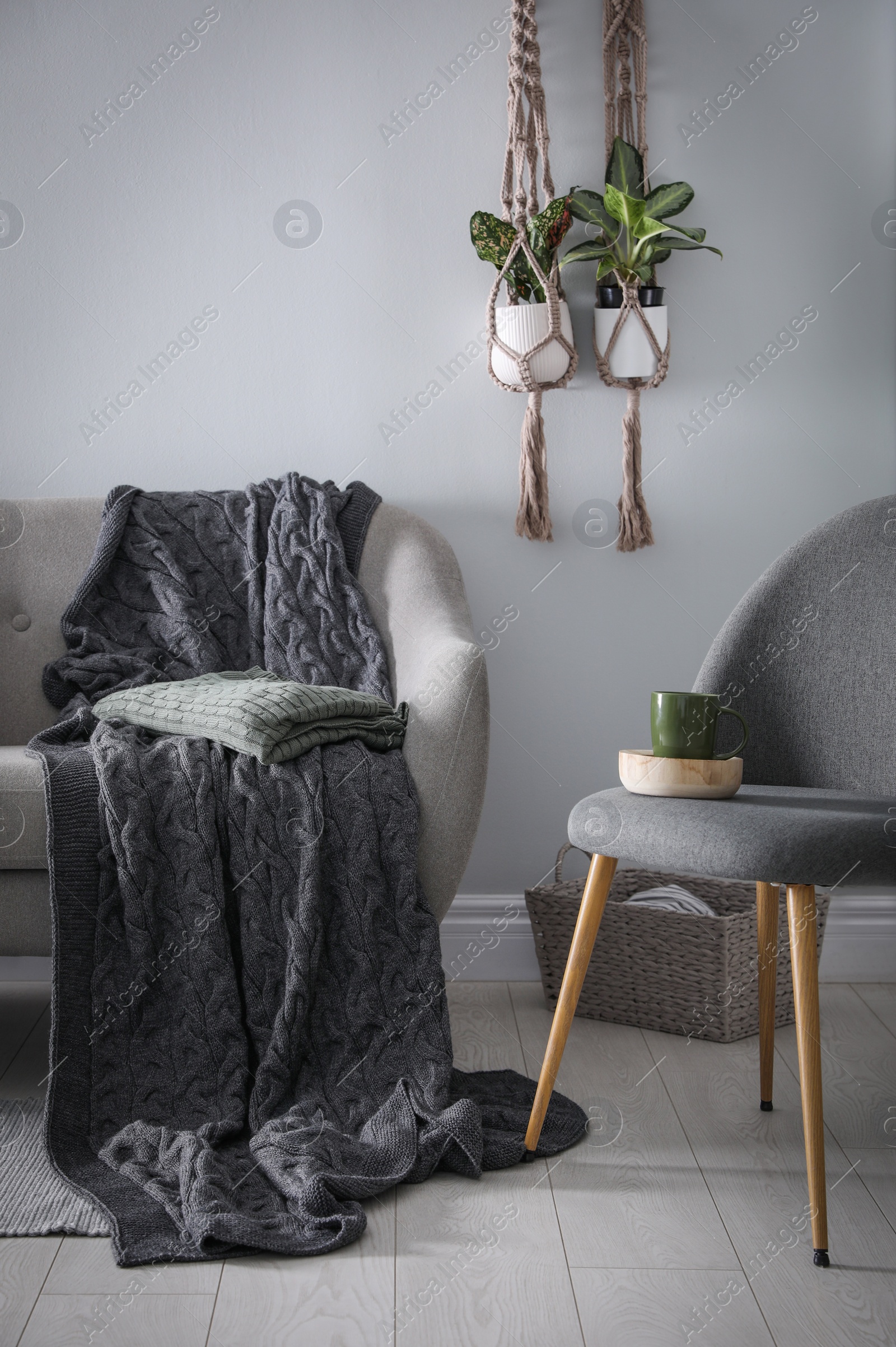 Photo of Soft knitted blanket on sofa in room. Home interior