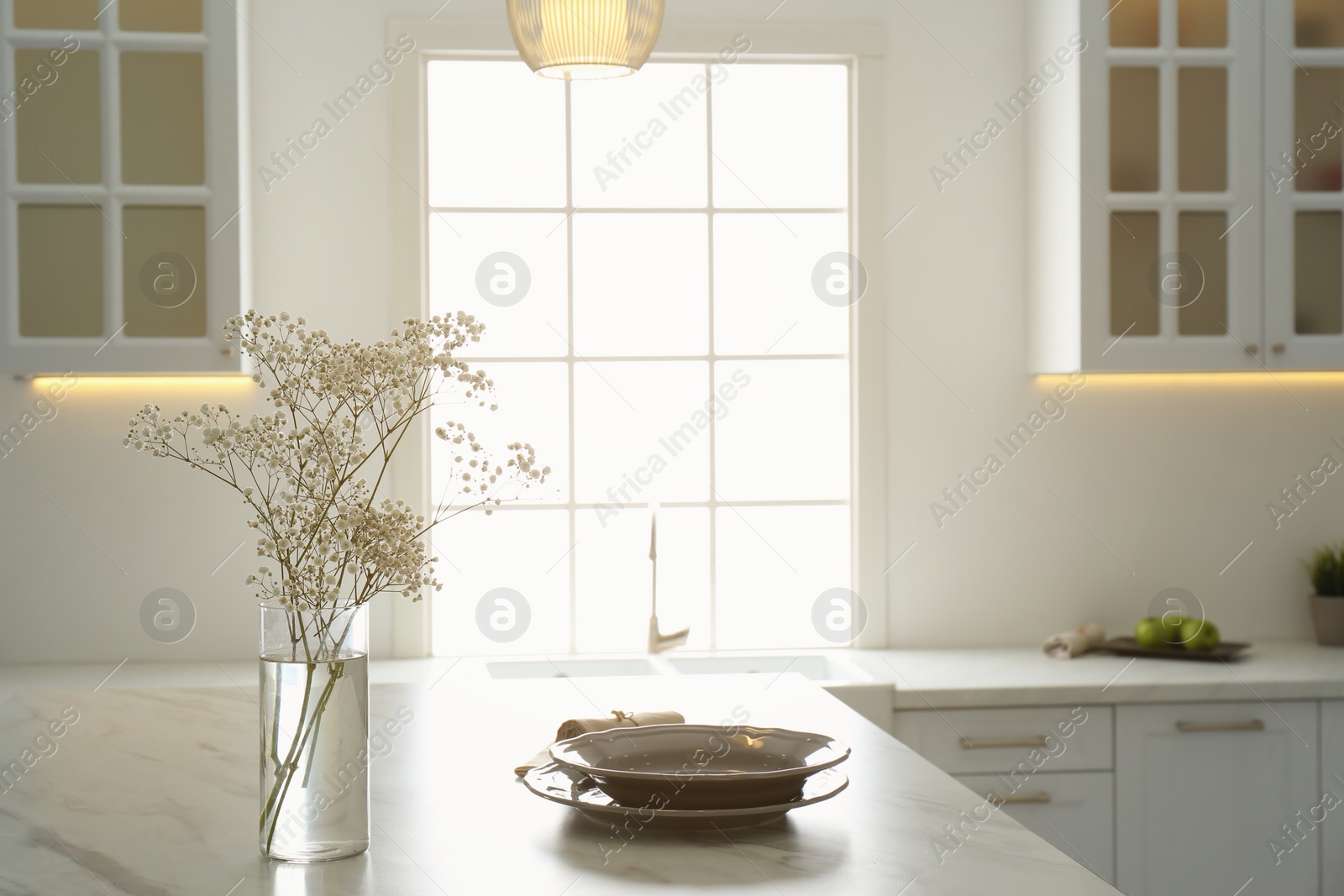 Photo of Beautiful plates and bouquet on table in kitchen