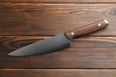 Photo of One knife on wooden table, top view