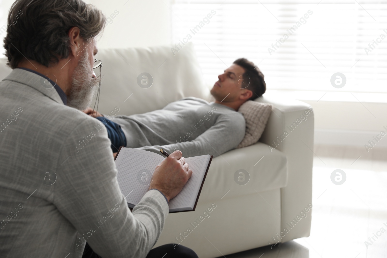 Photo of Psychotherapist and patient in office. Hypnotherapy session