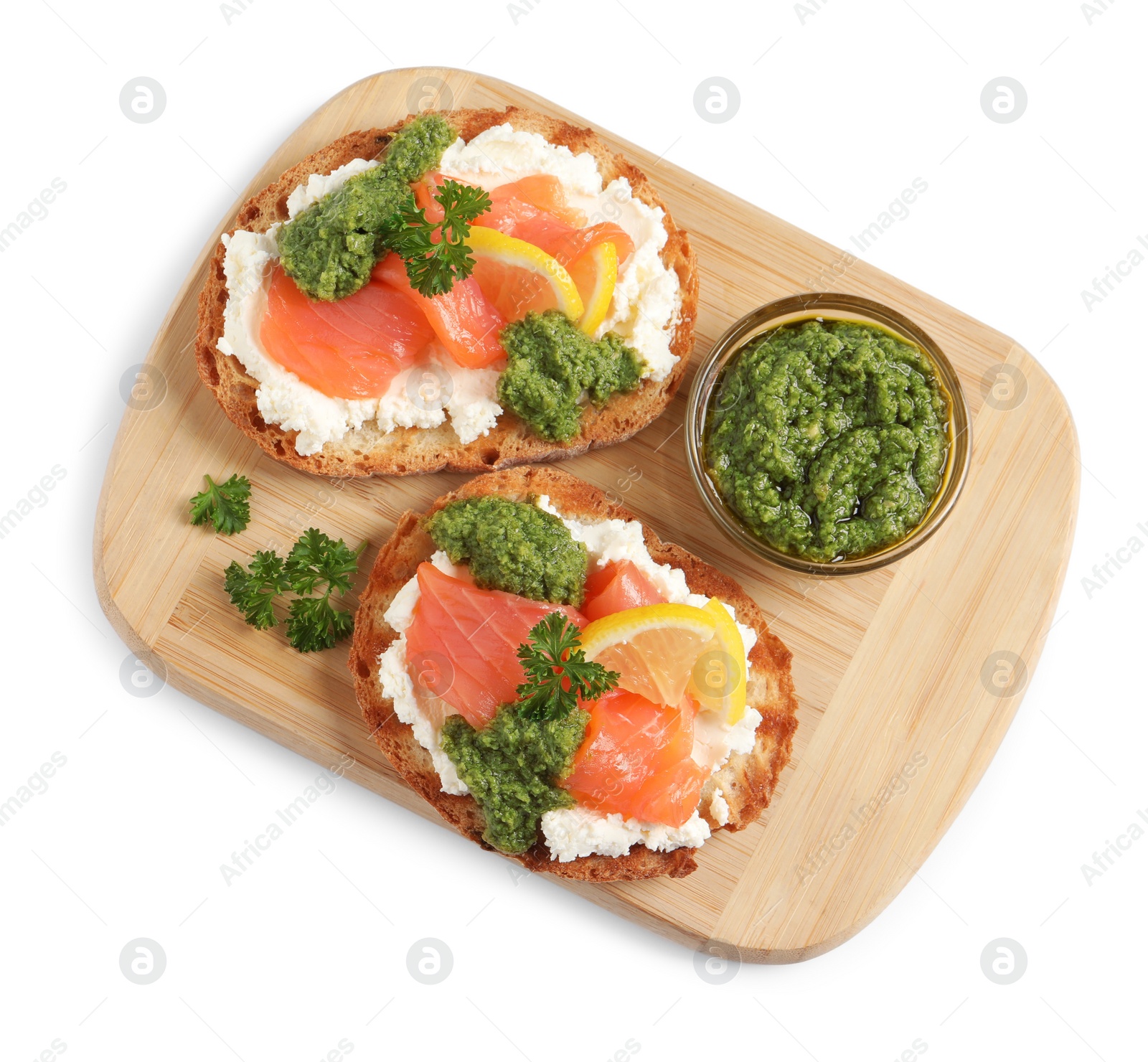 Photo of Delicious bruschettas with cream cheese, salmon and pesto sauce on white background, top view