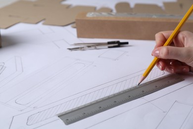 Photo of Woman creating packaging design on paper, closeup