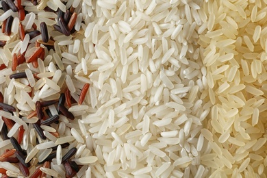 Photo of Brown and other types of rice as background, closeup