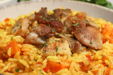 Photo of Delicious pilaf with meat in white bowl, closeup