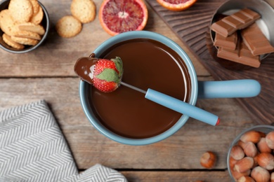 Photo of Flat lay composition with chocolate fondue on wooden background