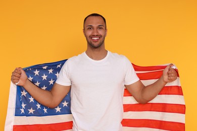 Photo of 4th of July - Independence Day of USA. Happy man with American flag on yellow background