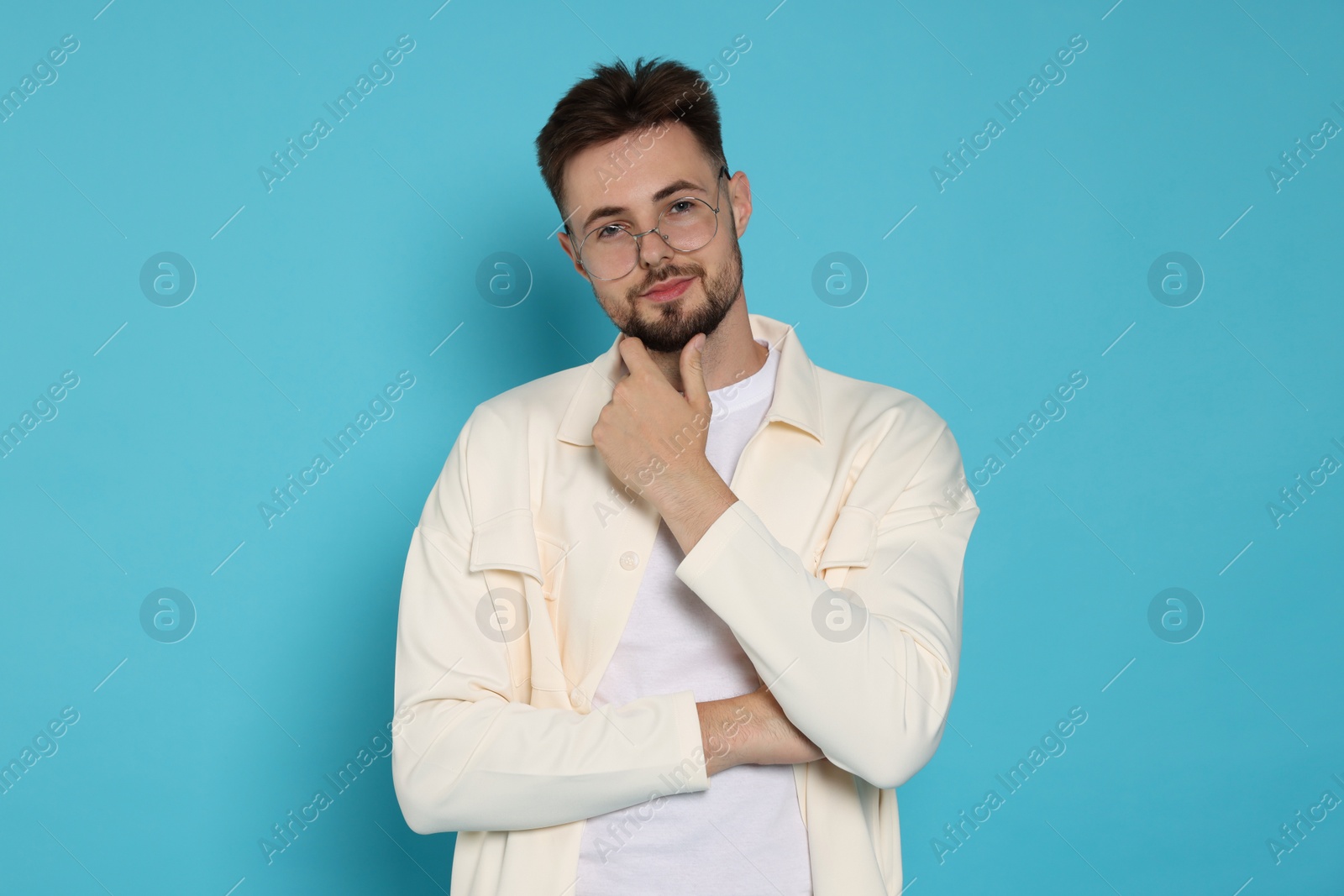 Photo of Handsome man in white jacket and eyeglasses with on light blue background