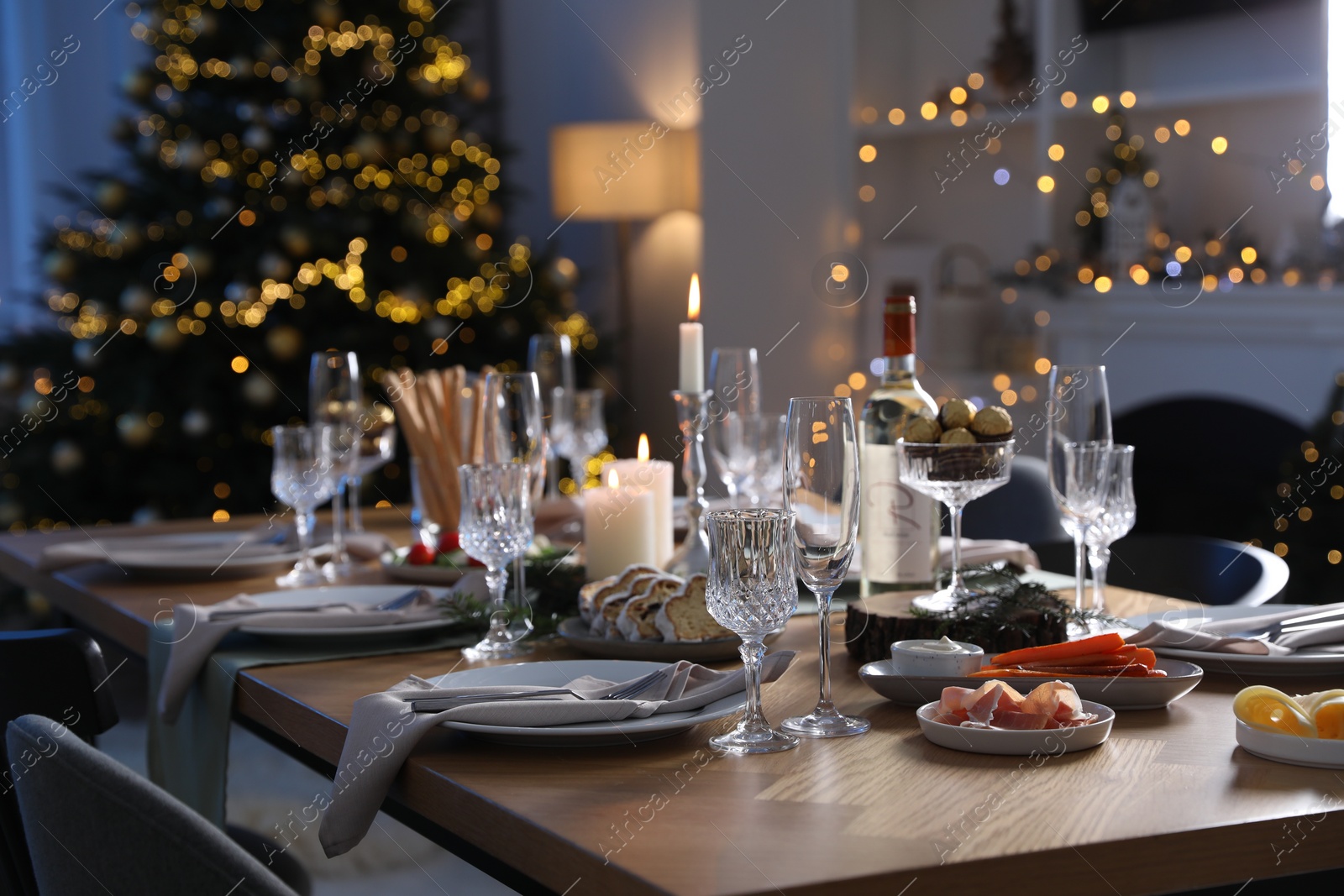 Photo of Christmas table setting with festive decor and dishware in room