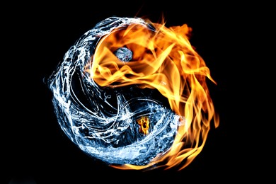 Fire flames and water splashes resembling Yin Yang symbol on black background. Feng Shui philosophy