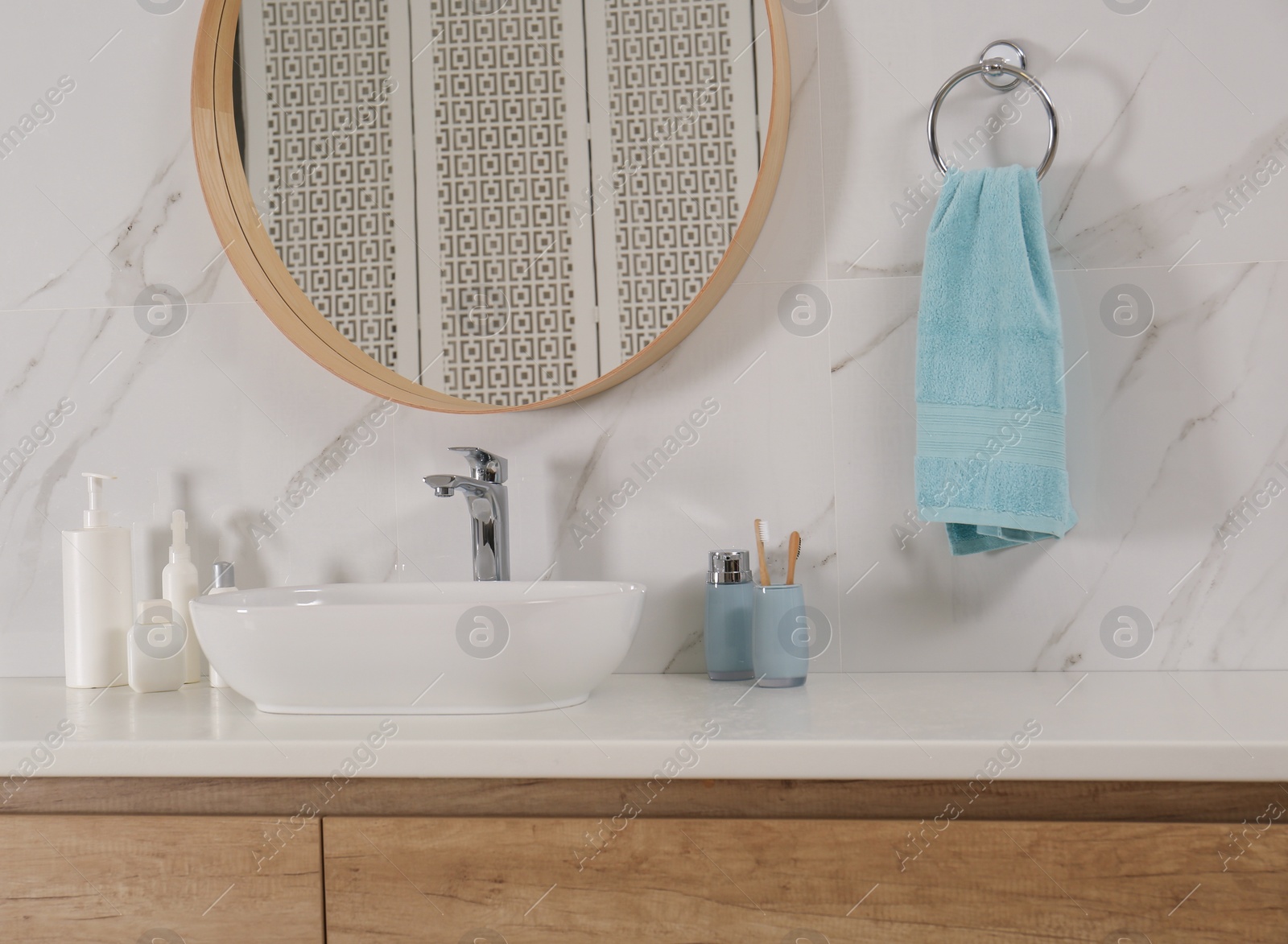 Photo of Bathroom interior with mirror, countertop and soft towel on wall