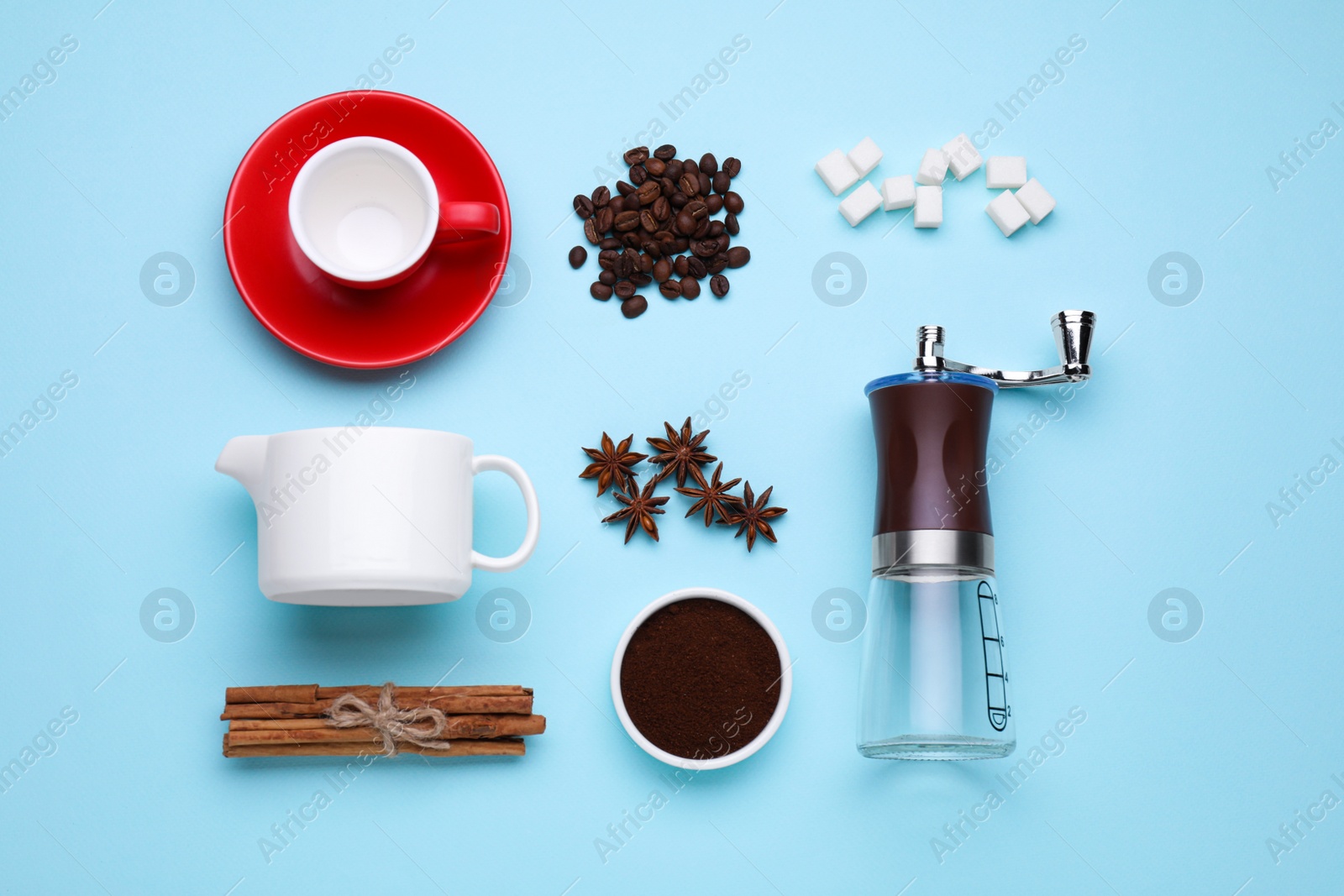 Photo of Flat lay composition with manual coffee grinder and spices on light blue background