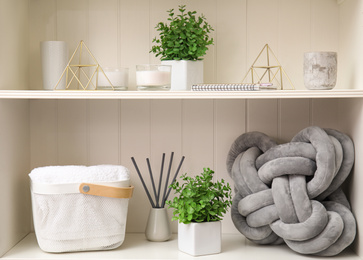 Photo of White shelving unit with plants and different decorative stuff