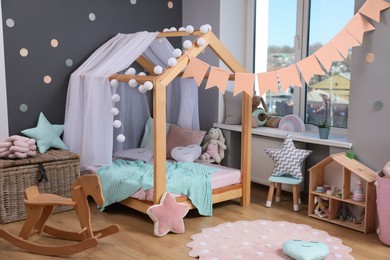 Stylish child room interior with house bed and different toys