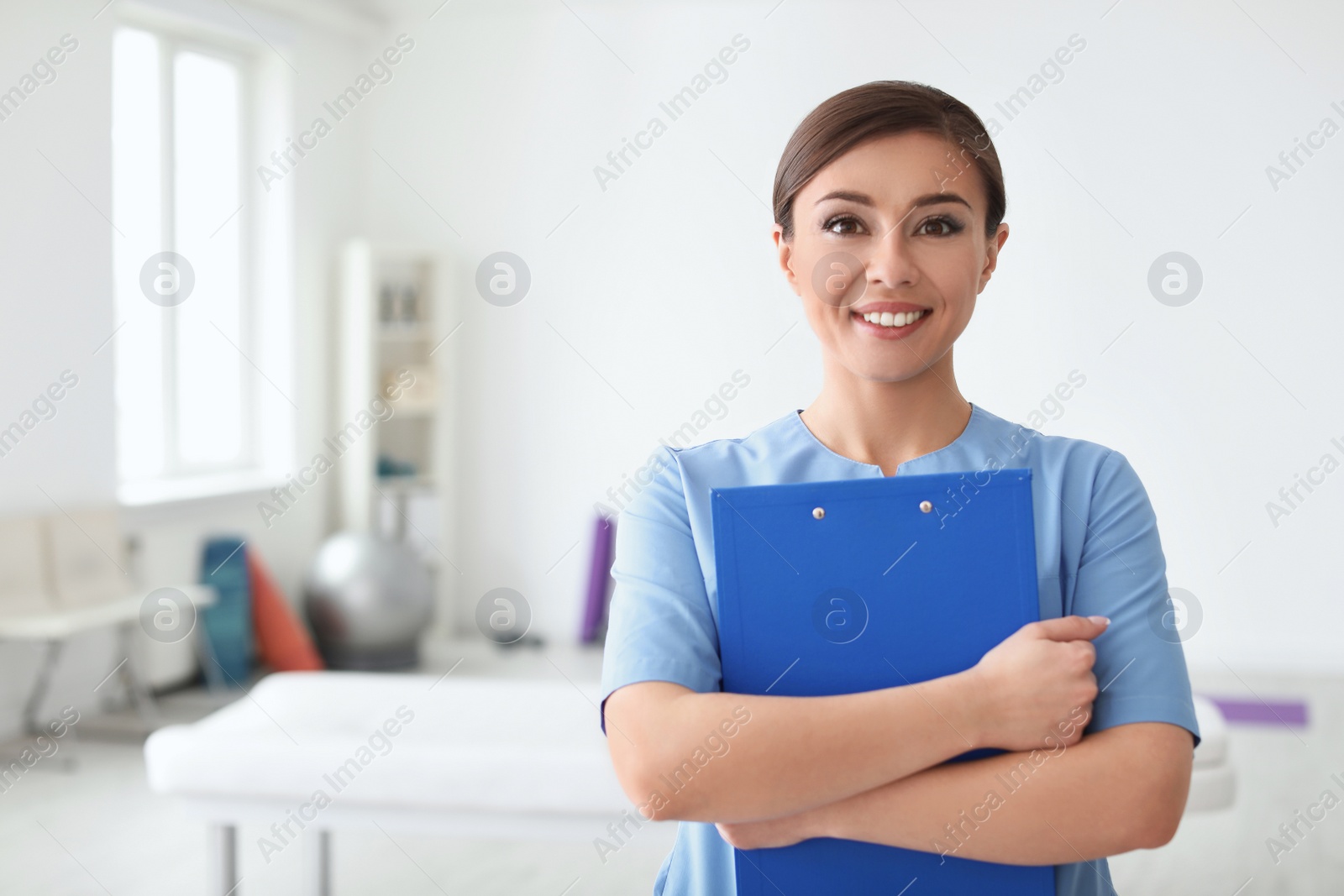 Photo of Young physiotherapist with clipboard in rehabilitation center