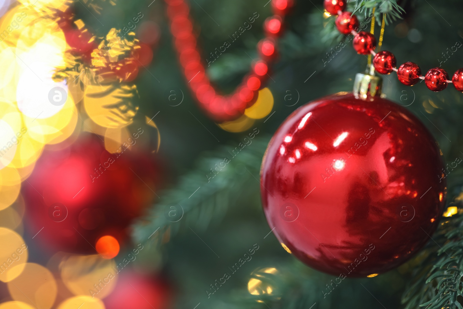 Photo of Closeup of red bauble hanging on Christmas tree, space for text. Bokeh effect