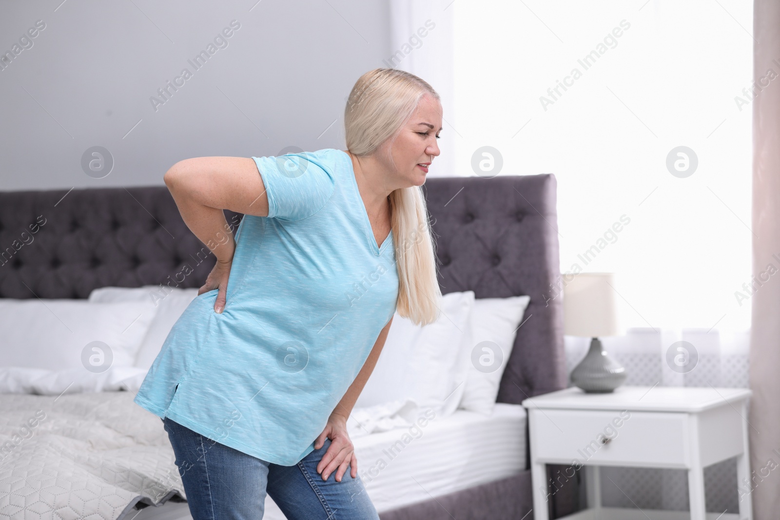 Photo of Senior woman suffering from back pain at home