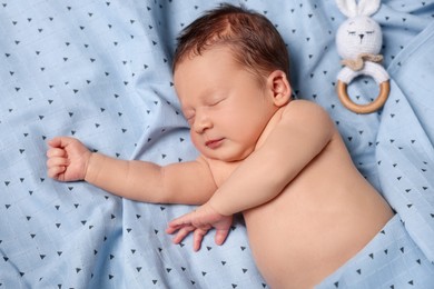 Photo of Cute newborn baby with toy bunny sleeping on bed