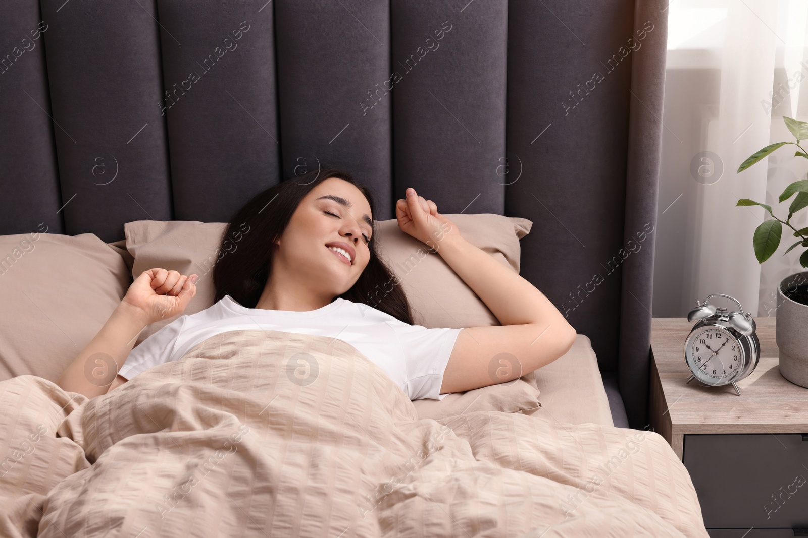 Photo of Beautiful woman stretching in soft bed at home