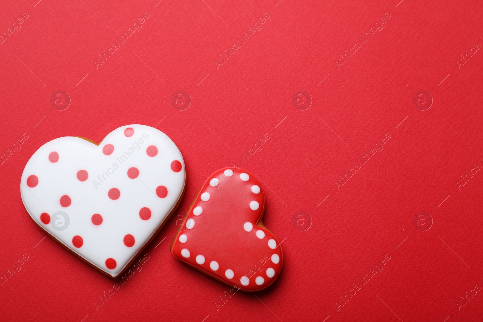 Photo of Valentine's day cookies on red background, flat lay. Space for text