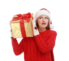 Photo of Emotional young woman in Santa hat with Christmas gift on white background