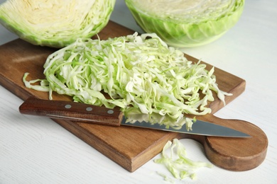 Cutting board with chopped and sliced cabbage on table