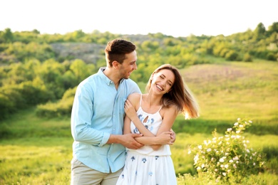 Cute young couple in love posing outdoors on sunny day