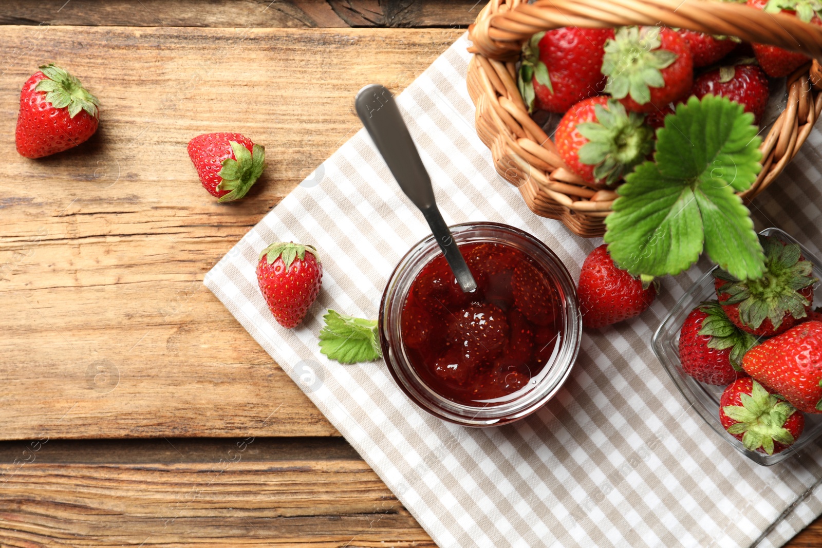 Photo of Delicious pickled strawberry jam and fresh berries on wooden table, flat lay