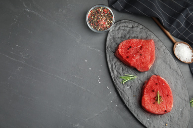 Photo of Flat lay composition with fresh beef cut on black table. Space for text